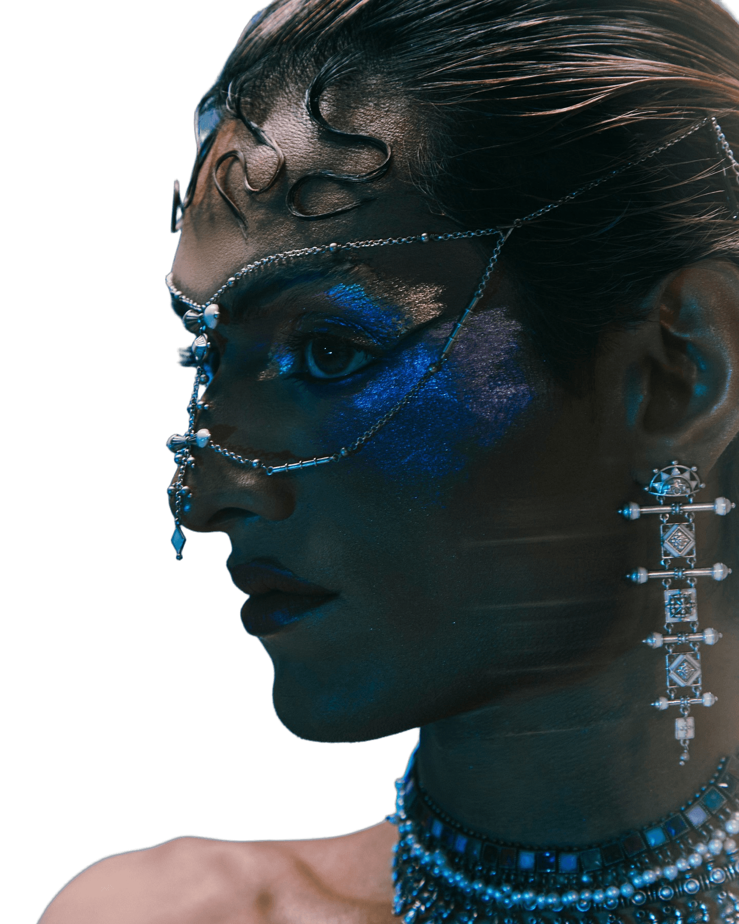 Blue-lit editorial portrait with chain jewelry